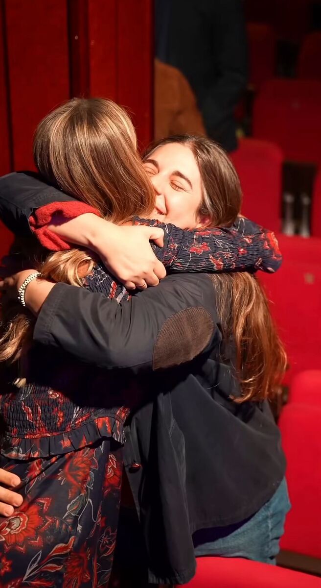 Abrazo emotivo entre asistentes al final de un evento RECARGA