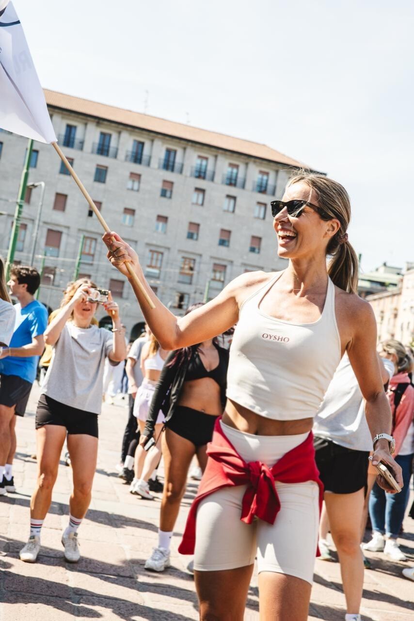 Amagoia Eizaguirre corriendo con una bandera de Oysho en un evento al aire libre